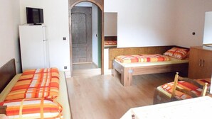A compact room with a bed, a small table, and a television on a white cabinet. - Zum Odenwald (Gorxheimertal)