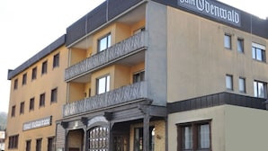 A hotel with a sign reading "Zum Odenwald" and a "Hotel Restaurant" sign below it. - Zum Odenwald (Gorxheimertal)