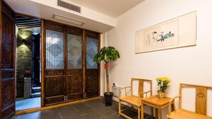 A traditional room with sliding doors, a potted plant, and two wooden chairs.