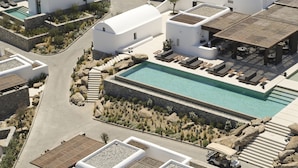 A resort with a central swimming pool, lounge areas, and a patio with outdoor seating.