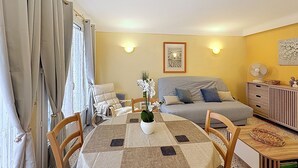 Une pièce confortable comprenant un lit, un canapé, une table à manger avec des chaises et un petit meuble.