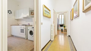 A narrow hallway with a washing machine, a radiator, and a clock on the wall. - GuestHost - APT X3 Loreto Città Studi M1/M2 & C.so Buenos Aires (Milano)
