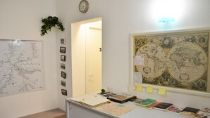 A room with a map, a desk with books, a clock, and a world map on the wall. - Roma Centrale Fidelis (Rome)
