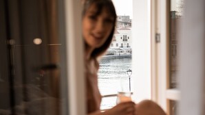 A person sitting by a window with a view of a river and buildings. - Divino Suites Chania (Chania)