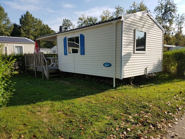 A mobile home with a covered porch and a small deck. - Camping la Comtesse (Belus)