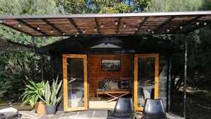 A covered outdoor seating area with a pool, stone flooring, and potted plants. - Villa with Private Pool, Surrounded by Mountains, Olive, Walnut and Orange Trees (Orgiva)