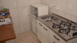 Una cocina funcional equipada con microondas, lavaplatos y cocina a gas.