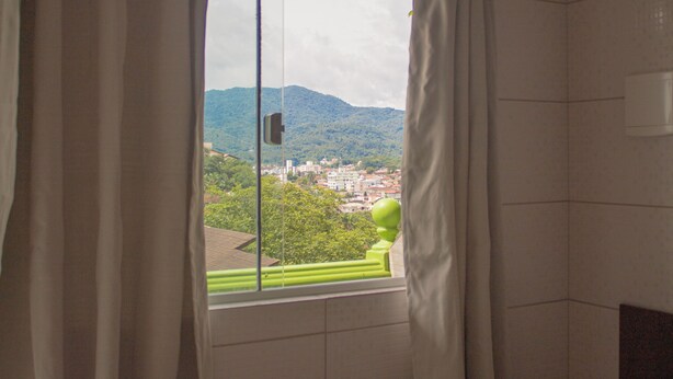 Un baño con vistas a una ciudad y montañas.