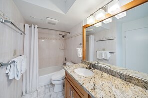 A modern bathroom with a marble sink, a large mirror, and a shower area. - Block to Beach! Koko Resorts at the Waikiki Banyan 30th Floor Deluxe Ocean View,Free parking & Wifi (Honolulu)