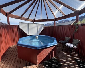 A hot tub under a pergola with a view of mountains. - Engimýri Lodge (Bakki)