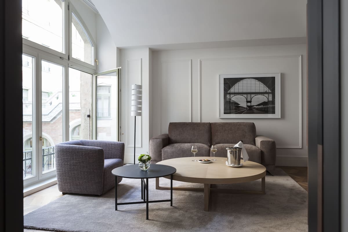 A modern living room with a grey sofa, a round coffee table, and a framed picture on the wall.