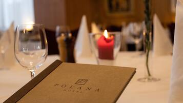 A menu with the text 'POLANA HOTEL' on a table set for dining.