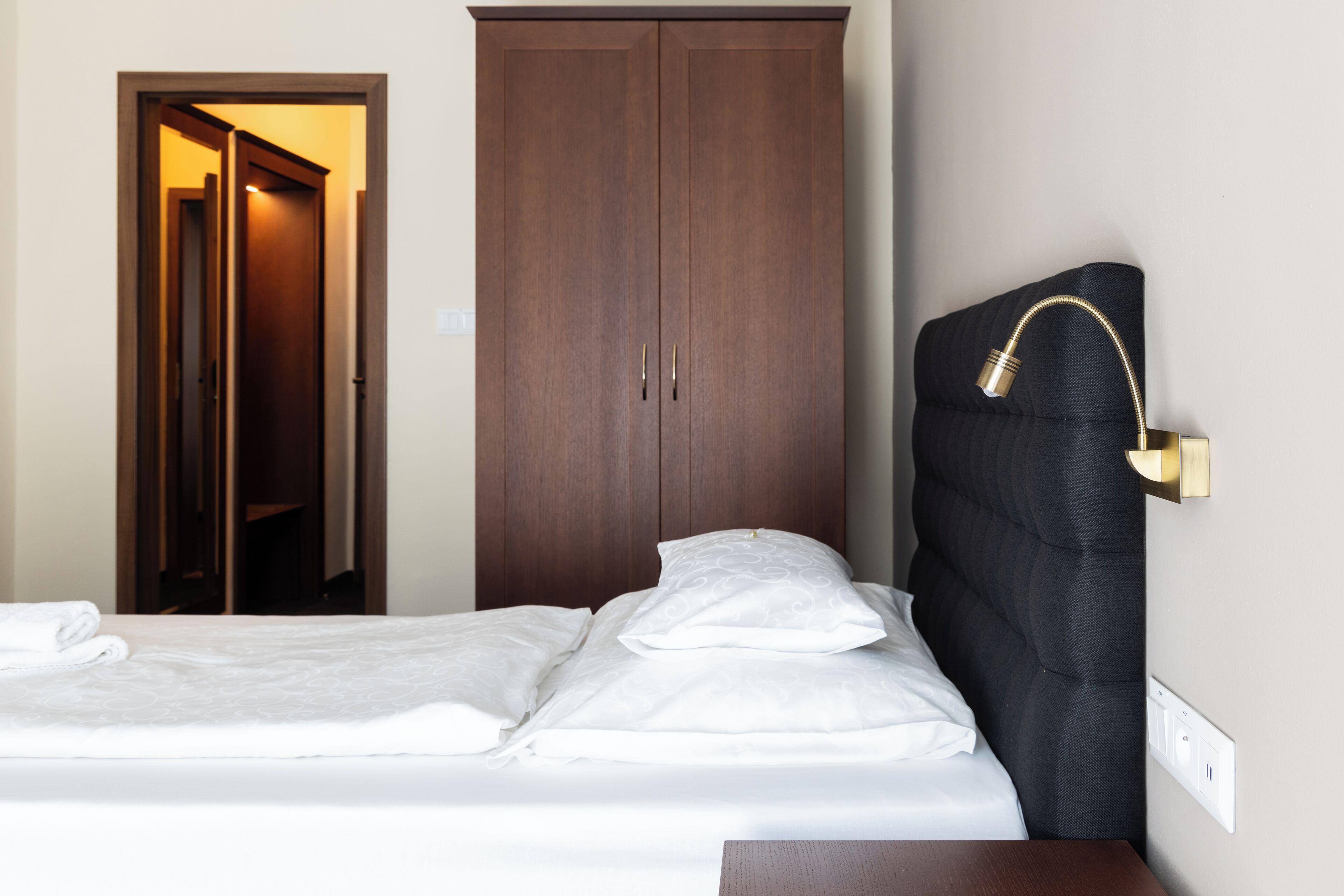 Une chambre d’hôtel avec un lit, une armoire et une table de chevet.