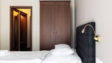 Une chambre d’hôtel avec un lit, une armoire et une table de chevet.