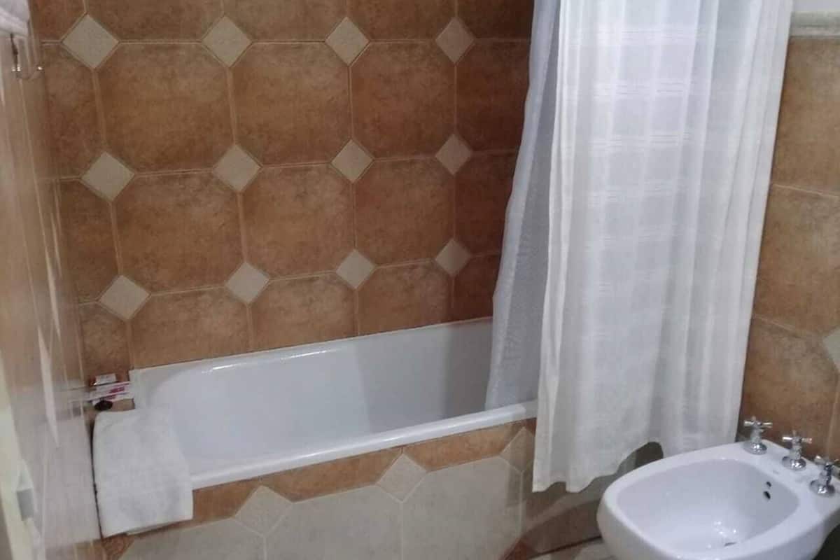 Standaard vierpersoonskamer | Badkamer | Een douche, handdoeken, zeep, shampoo