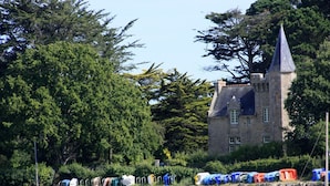 A stone building with a conical roof, surrounded by trees and a stone wall. - Le Grand Large - house in Locmariaquer centre, 4p (Locmariaquer)