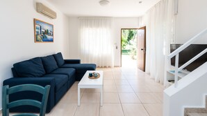 Ein modernes Wohnzimmer mit einem dunkelblauen Sofa, einem weißen Couchtisch und einem Gemälde an der Wand.