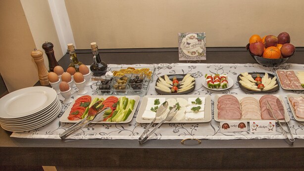 A buffet table with various food items and condiments.