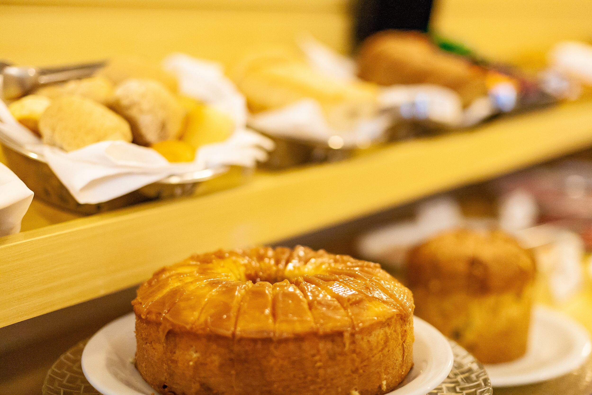 A buffet with various baked goods including a bundt cake and muffins.