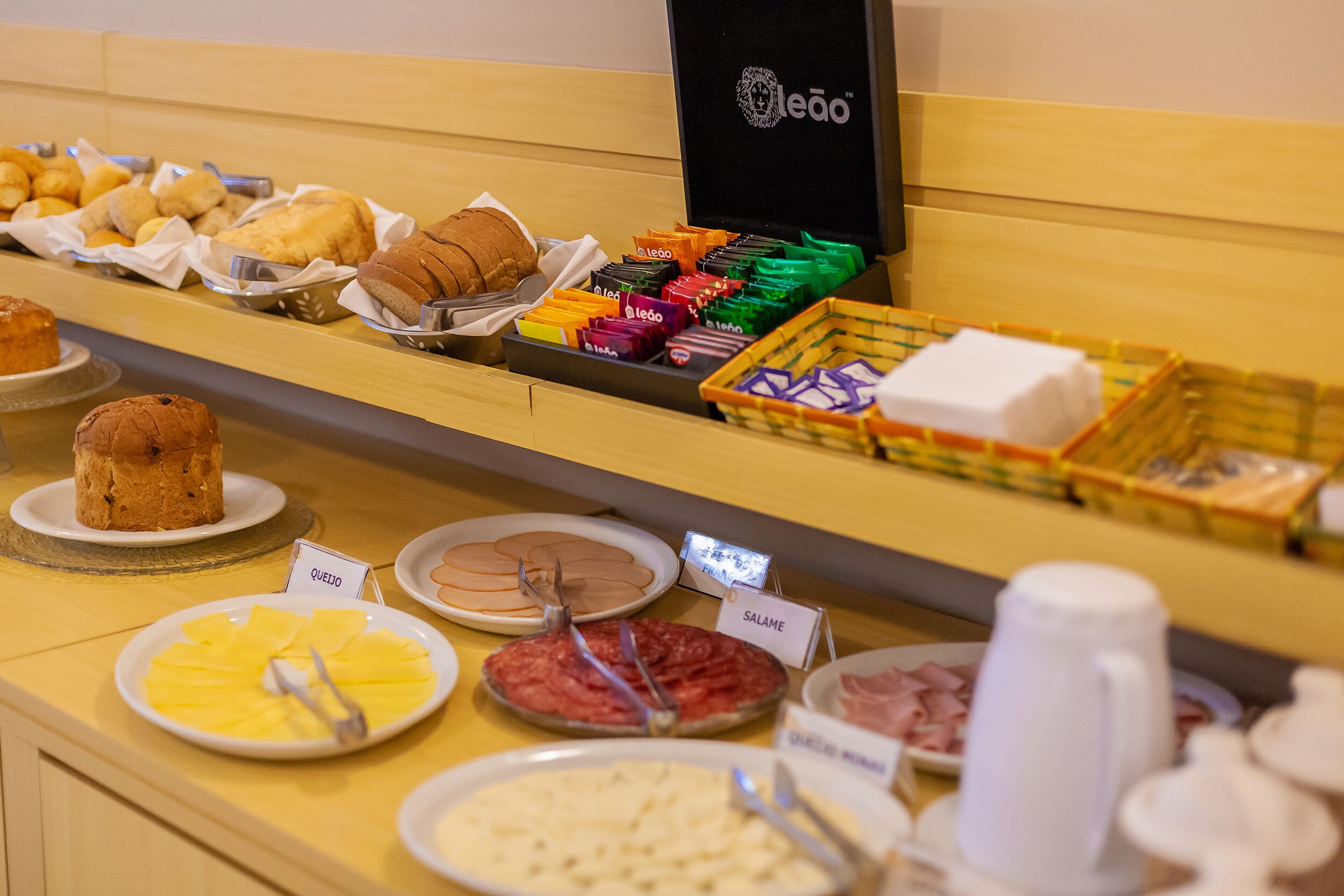 Un buffet con diversi cibi, tra cui pane, pasticcini e una postazione per il caffè.