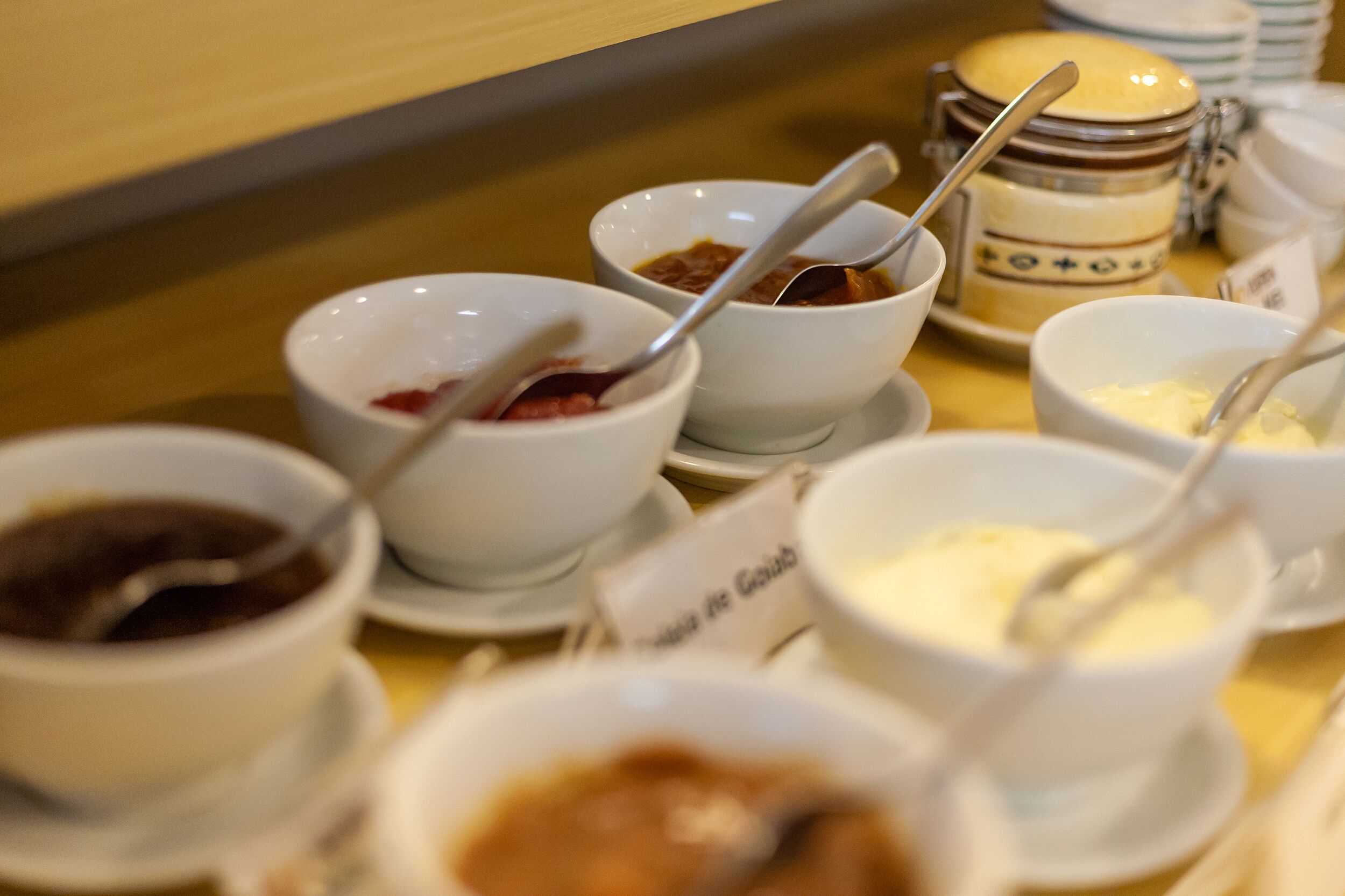 Una mesa de buffet con varios recipientes de comida y salsas.