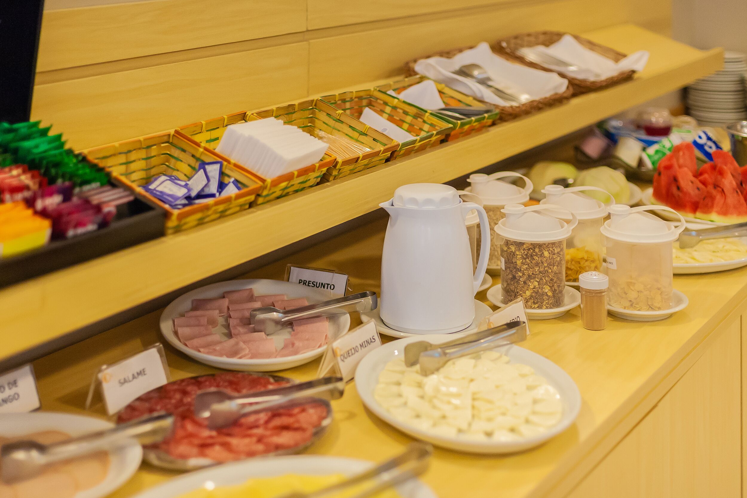 A buffet with various food items and condiments.