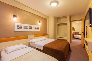 Deluxe Triple Room | Minibar, in-room safe, desk, iron/ironing board