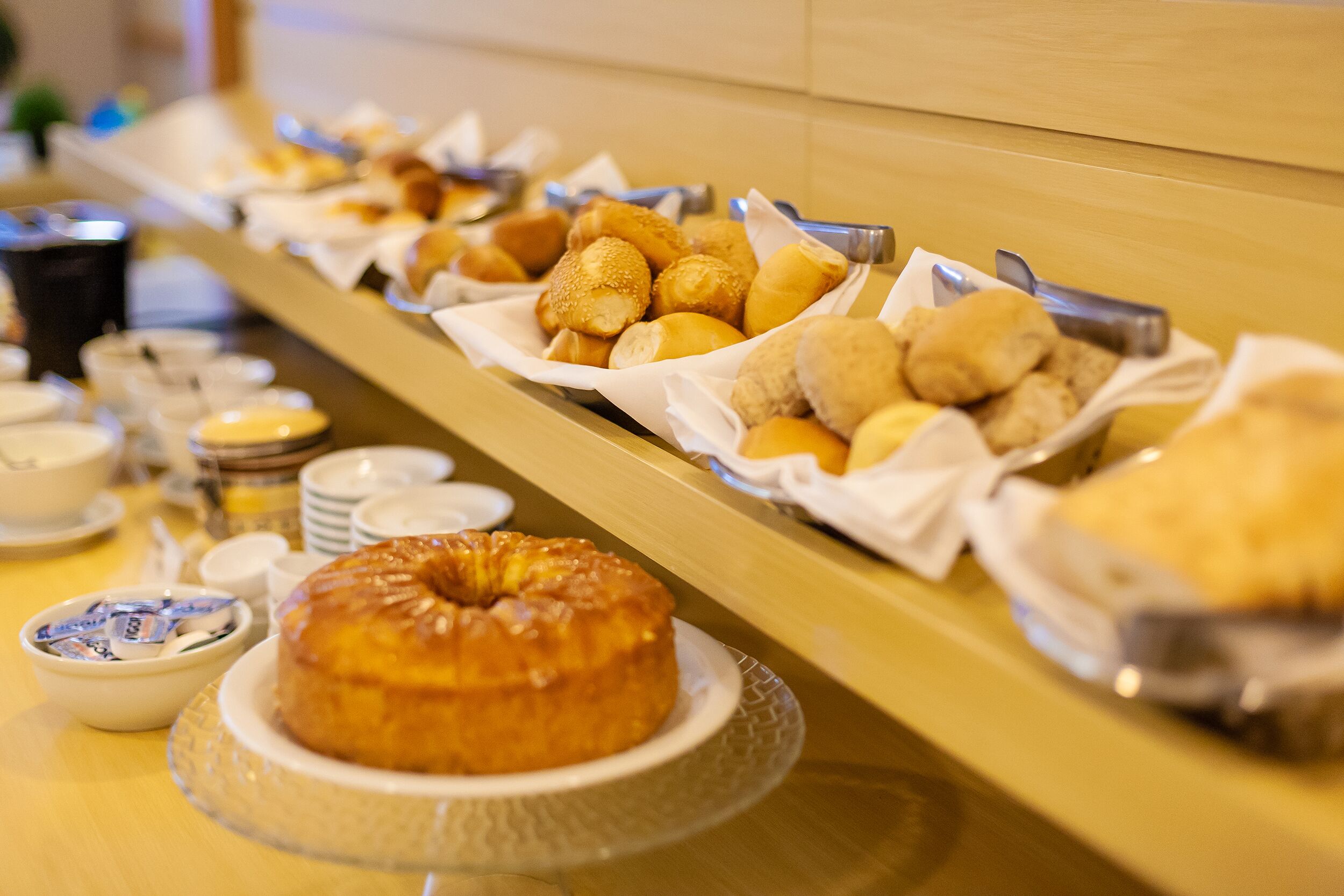 Ein Buffet mit verschiedenen Backwaren und einer Torte auf einer Glasplatte.