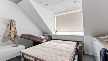 Quarto moderno com beliche, mesinha de cabeceira, janela com vista e parede branca.