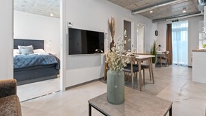 A modern hotel room with a bed, a dining area, and a living space. - Aalesund City Apartment (Ålesund)