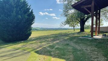 Ein grüner Außenbereich mit einer Holzpergola und einer Bank.