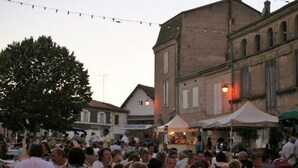 A crowded outdoor event with people gathered around tables, possibly a market or festival, in a town square with historic buildings. - Rural country retreat with private heated pool and driving range! (Verteuil-D'agenais)