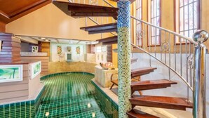 A spiral staircase with green-tiled steps leading to a second-floor area with a pool. - Angel Pool Villa Phuket (Ratsada)