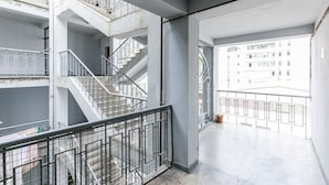 Monitasoinen sisätila, jossa on portaikko, metallikaiteet ja näkymä ulkopuolella oleviin rakennuksiin.