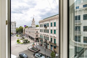 A view of a city street with buildings, a roundabout, and a flag on a building. - Gamers apartment (Tbilisi)