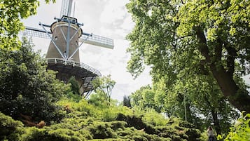 A traditional windmill surrounded by lush greenery and trees.