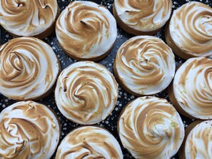 A close-up of a dozen cupcakes with a swirl of frosting on top. - Fletcher Hotel-Restaurant De Oude Gevangenis - Alkmaar (Alkmaar)