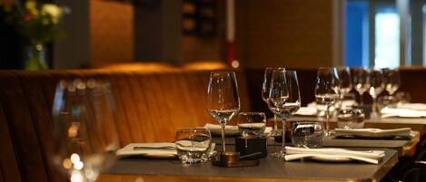 Un comedor de restaurante con mesas y cabinas dispuestas para atender a los comensales.