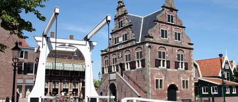 Un edificio histórico con una torre destacada y una gran entrada en arco.