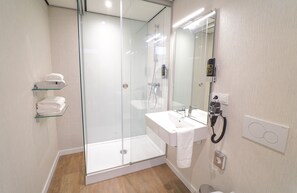 A modern bathroom with a glass-enclosed shower, a white sink, and a towel rack. - Fletcher Hotel-Restaurant De Oude Gevangenis - Alkmaar (Alkmaar)