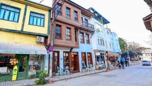 A street view with buildings, outdoor seating, and a 'No Parking' sign. - Trilye Bay C Konak (Mudanya)