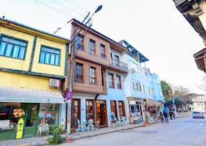 A street view with buildings, outdoor seating, and a 'No Parking' sign.