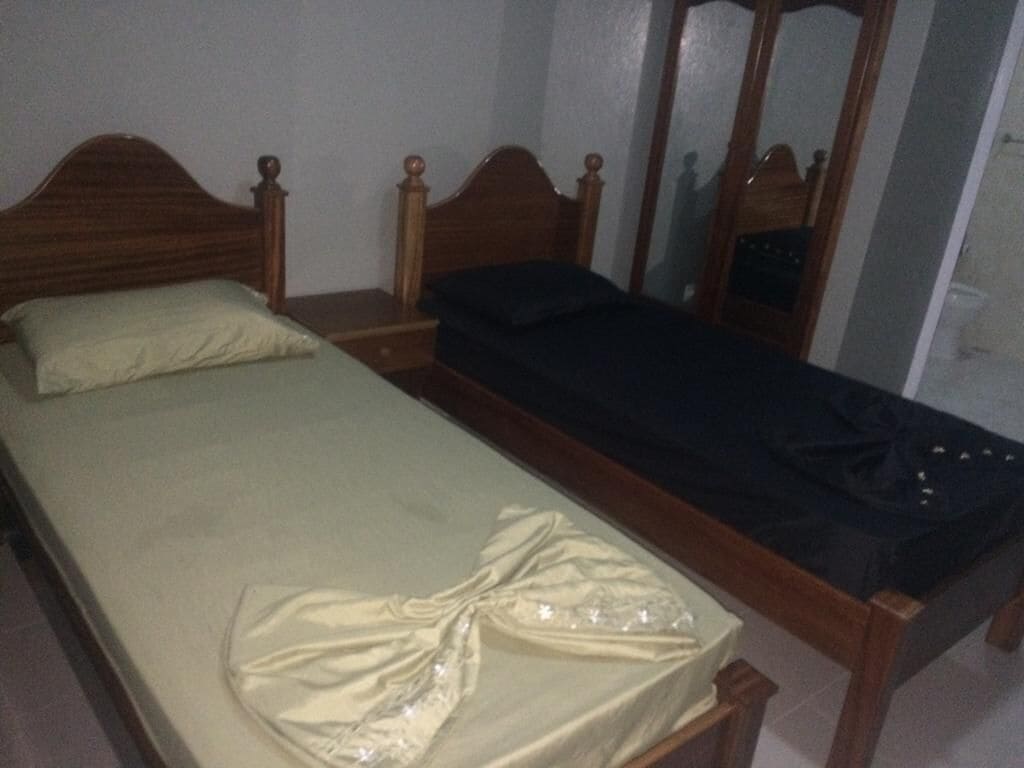 A single bed with a wooden headboard and a bedside table.