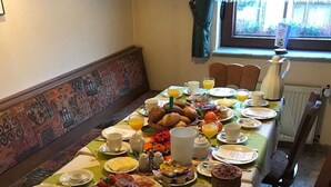 A breakfast table set with various dishes, including bread, fruits, and beverages. - Ferienwohnung Reifberg (Ilmenau)