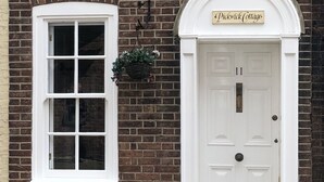 A brick building with a white door labeled "Pickwick Cottage" and the number 11. - * SEE OVER 170 AMAZING GUEST REVIEWS ON AIRBNB * Location * Location * Location (Poole)