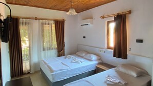 A room with two beds, wooden ceiling, and a TV on a desk. - Plaj Hotel (Kemer)