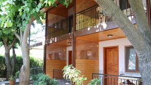 A multi-story building with balconies, wooden doors, and potted plants. - Plaj Hotel (Kemer)