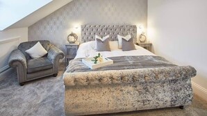 A bedroom with a large bed, a chair, and a nightstand. - Host & Stay | Simba House (Saltburn-by-the-Sea)