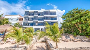 A modern hotel with a multi-story structure, a beachside location, and a pool area with sun loungers. - Perfect for a couple to enjoy the breathtaking views of the Caribbean! (Akumal)