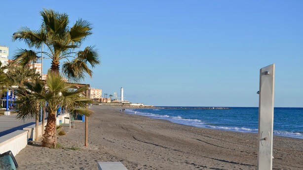 A beach with palm trees, a lighthouse, and a pier in the background. - APARTMENT SEEVIEW ON THE BEACH PARKING ALL INCLUSIVE TORROX NERJA MALAGA SPAIN (Torrox Costa)